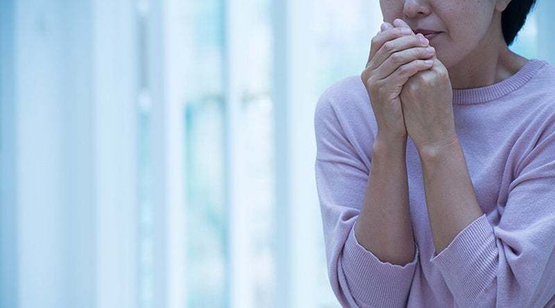 冷たい手をこすり合わせる女性